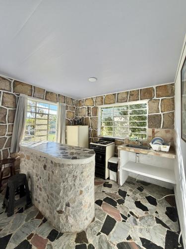 a kitchen with a stone tub in the middle of a room at Cabañas El Itali in Fusagasuga