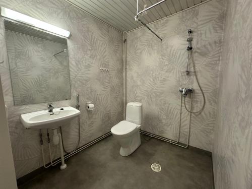 a bathroom with a toilet and a sink and a shower at Mysig Lägenhet in Kokkola
