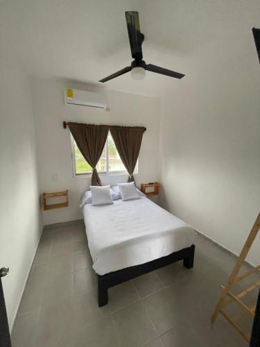 a bedroom with a bed and a ceiling fan at Departamento al lado del Mar in Barra Nueva