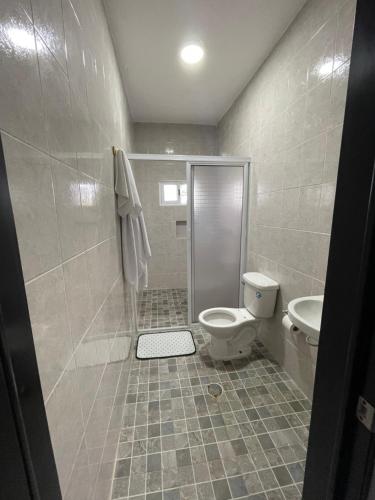 a bathroom with a shower and a toilet and a sink at Departamento al lado del Mar in Barra Nueva