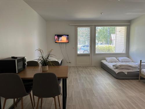 a living room with a table and a bed in a room at Mysig Lägenhet in Kokkola