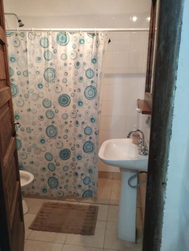 a bathroom with a shower curtain and a sink at Casa con bajada al rio in Villa Cura Brochero