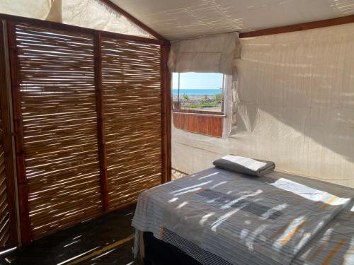 a small room with a bed and a window at La Bahia de Makale in Pisco