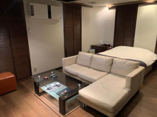 a living room with a couch and a coffee table at Rplus八千代 in Chiba