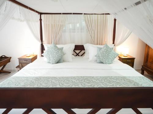 a bedroom with a large bed with white sheets and pillows at Kandy 888 Villa in Kandy