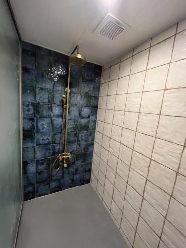 ein Badezimmer mit Dusche und gefliester Wand in der Unterkunft mrsbutt inn in Aka