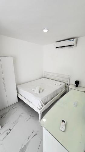 a white room with a bed and a remote control at my house on the upper beach in Villas del Mar