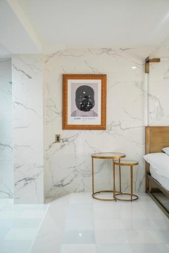 a bedroom with white marble walls and a table and a bed at THE ROOT2 HOTEL in Kyoto