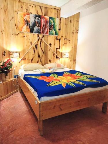 a bedroom with a bed with a wooden wall at Hostel La Ballena Backpacker in Las Galeras