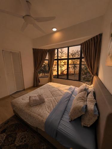 a bedroom with a large bed with a ceiling fan at Seaview mutiara melaka Pantai puteri in Gua Sai
