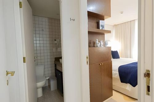 a small bedroom with a bed and a bathroom at Grand Mercure Itaim Bibi | Premium & Luxury Flat in São Paulo