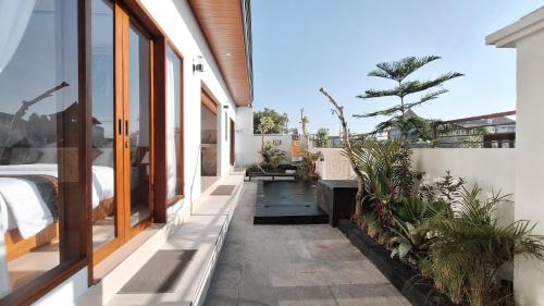 a house with a courtyard with potted plants at Villa Kasuri Bali in Blahbatu