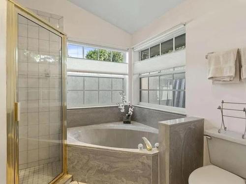 a bathroom with a tub and a shower and a toilet at Hutchinson River House in Fort Pierce