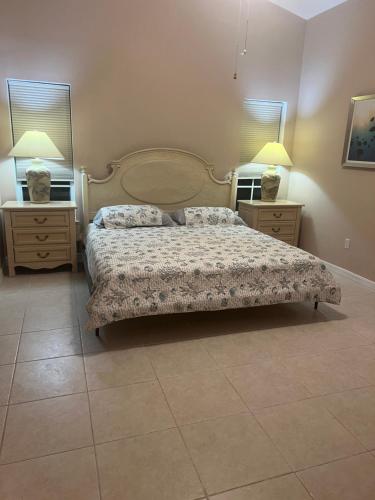 a bedroom with a large bed and two night stands at Hutchinson River House in Fort Pierce