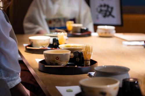 a table with bowls and cups on top of it at Hotel Resol Trinity Kyoto in Kyoto