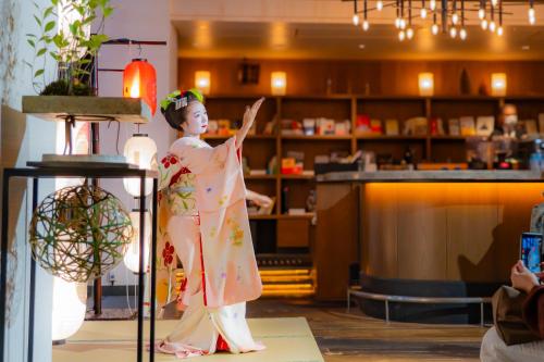 a statue of a woman in a kimono in a store at Hotel Resol Trinity Kyoto in Kyoto