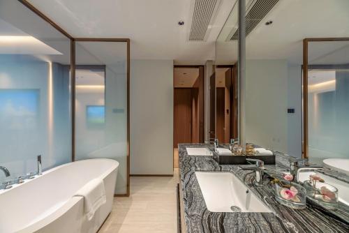 a bathroom with two sinks and a large tub at 厦门伟尔酒店Xiamen Well Hotel in Gaolin