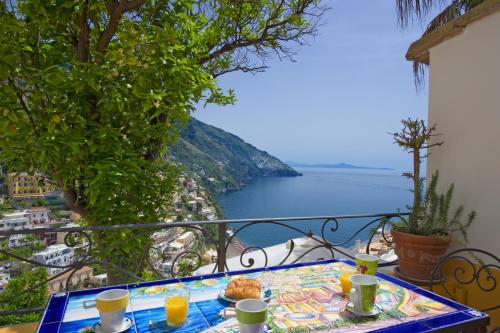 a table with food on a balcony with a view of the ocean at Casa Hellen Positano center in Positano