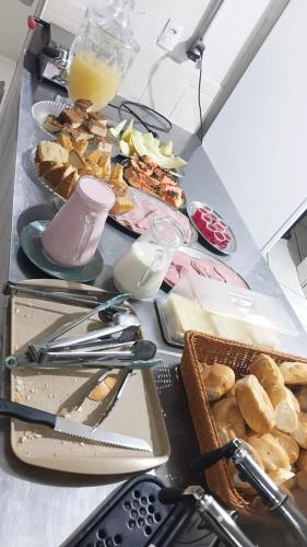 a table with a bunch of different types of food at Hotel Gênio in Pouso Alegre