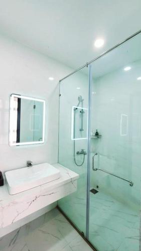 a bathroom with a sink and a glass shower at Xan hotel in Phú Quốc