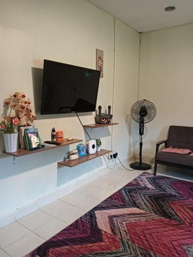 a living room with a flat screen tv on a wall at villa tempoyak homestay in Pantai Cenang