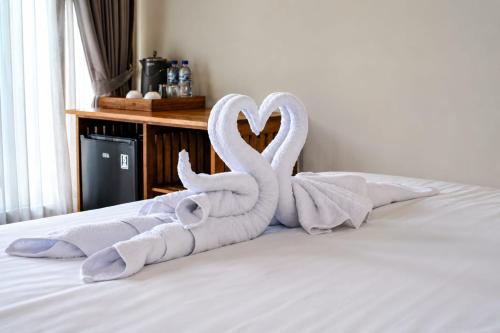 two towel swans are sitting on a bed at SARALA sidemen guest house in Sidemen