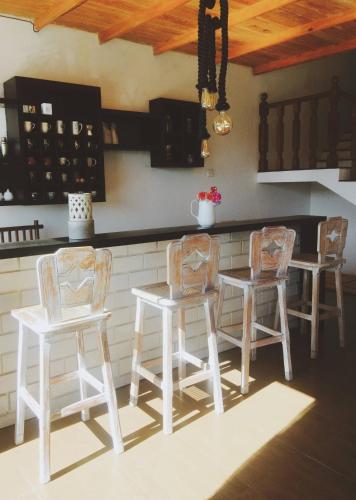 a kitchen with three chairs and a table and a counter at Melford Nuwaraeliya in Nuwara Eliya