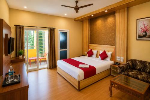 a hotel room with a bed and a couch at Iyal Hotels and Resorts in Salem