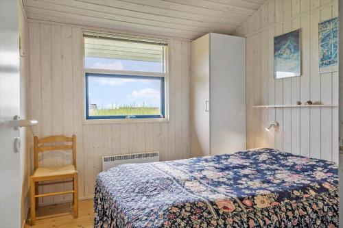 a bedroom with a bed and a window and a chair at G112-Lemvig-Anemonevej-12 in Lemvig