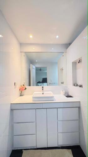 a white bathroom with a sink and a mirror at Sergi's Resort and Hotel in Palompon