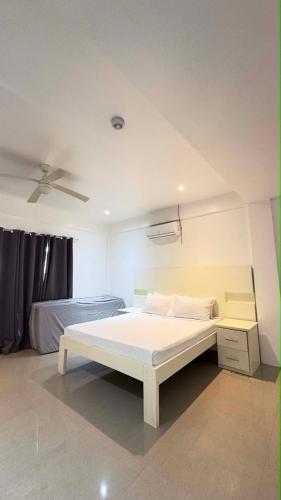a bedroom with a white bed and a ceiling at Sergi's Resort and Hotel in Palompon