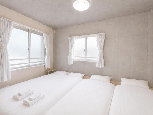 two beds in a room with two windows at NEW OPEN!! SLEEPLAB 池袋 -ikebukuro- in Tokyo