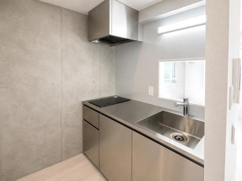 a kitchen with a stainless steel sink and a window at NEW OPEN!! SLEEPLAB 池袋 -ikebukuro- in Tokyo
