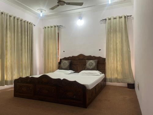 a bedroom with a wooden bed with curtains at p&q's guest house in Srinagar