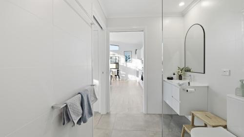 a white bathroom with a sink and a mirror at WARM Sunlit Sustainable north facing Studio in Hawker
