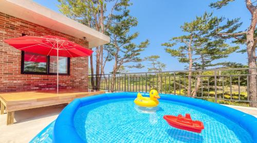 a swimming pool with a rubber duck and a toy boat at Goseong Pinetree Pension in Goseong