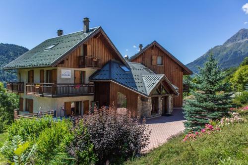 ein großes Holzhaus mit grünem Dach in der Unterkunft Chalet Saskia - Simply Perfect in Vaujany
