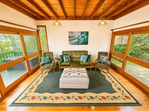 a living room with a couch and chairs on a rug at Cottage on the Lake - peaceful Burrill Lake escape in Burrill Lake