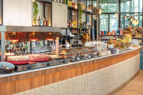 a buffet line with food on display in a restaurant at INNSiDE by Meliá Amsterdam in Amsterdam