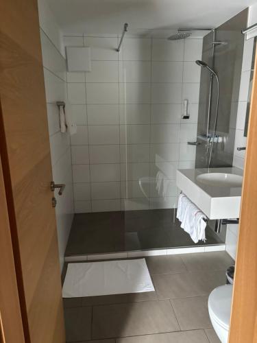 a bathroom with a shower and a sink at Hotel Cafe Lorenz in Hohenems
