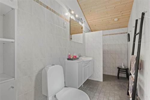 a white bathroom with a toilet and a sink at 10039-Nykobing-Sj-Rishoj-Sidevej-9 in Nakke