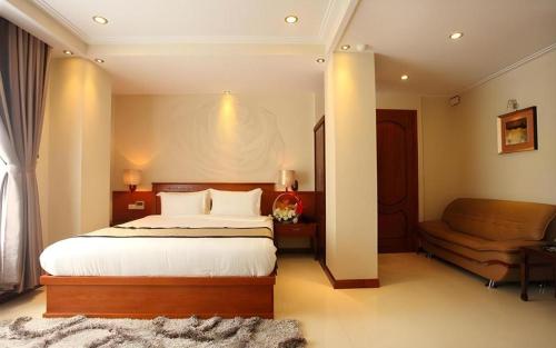 a bedroom with a large bed and a couch at Au Lac 2 Hotel in Ho Chi Minh City