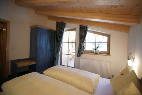 a bedroom with two beds and a window at Dorfappartements Söll in Söll