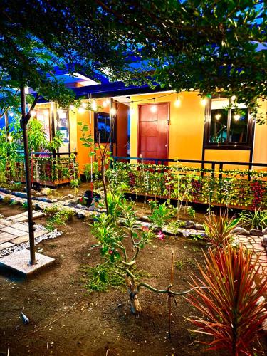 a house with a lot of plants in front of it at BalaiBesa Transient House in Lingayen