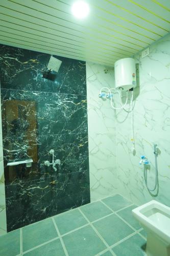 a bathroom with a sink and a green marble wall at The Casa Comforts in New Hampi