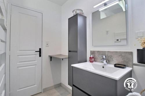 a white bathroom with a sink and a mirror at Le clos kerroux in Noyal-Muzillac