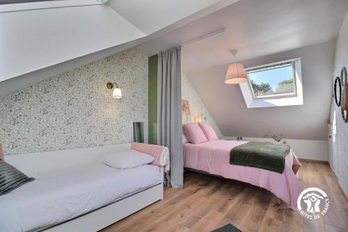 a bedroom with two beds and a window at Le clos kerroux in Noyal-Muzillac