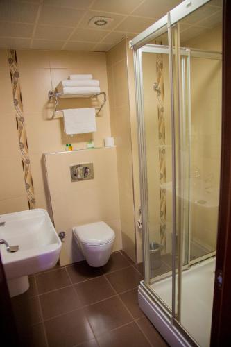 a bathroom with a toilet and a glass shower at Kelesler Park Hotel in Ereğli