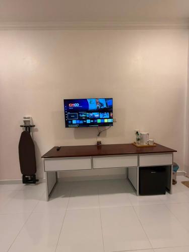 a desk with a flat screen tv on a wall at Bunohan Villa Roomstay in Tumpat