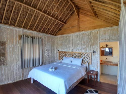 a bedroom with a bed in a room with wooden ceilings at Lombok eco Lumbung in Gili Gede